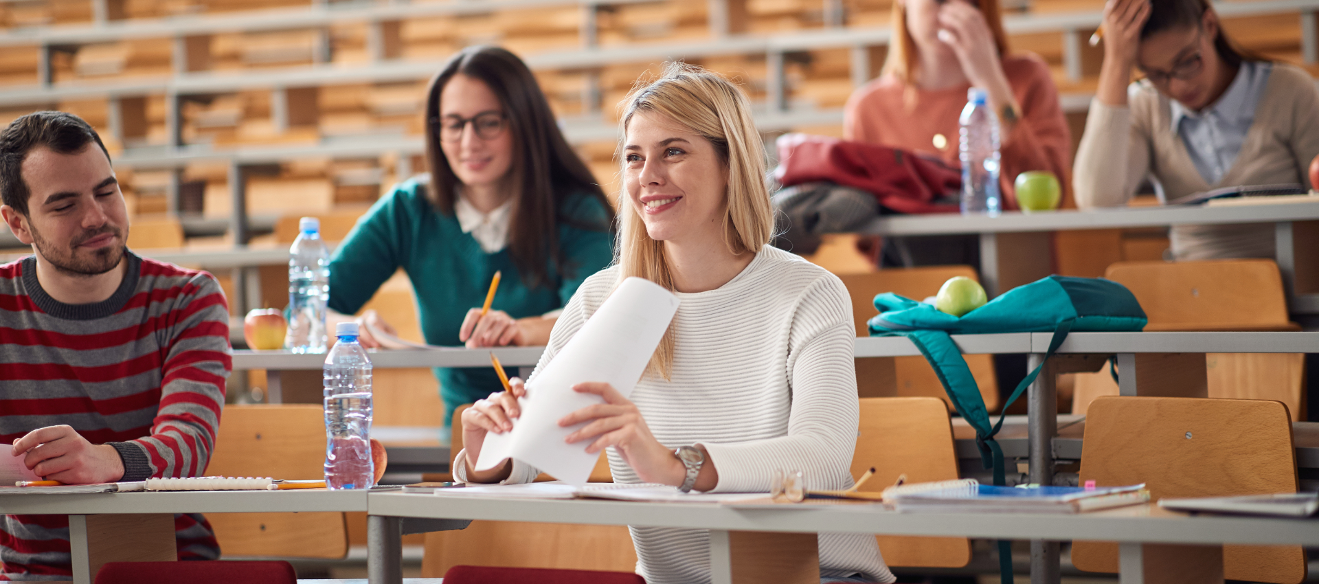 Eine Lehramtsstudentin im Hörsaal - Auch im Studium sind wir an deiner Seite!